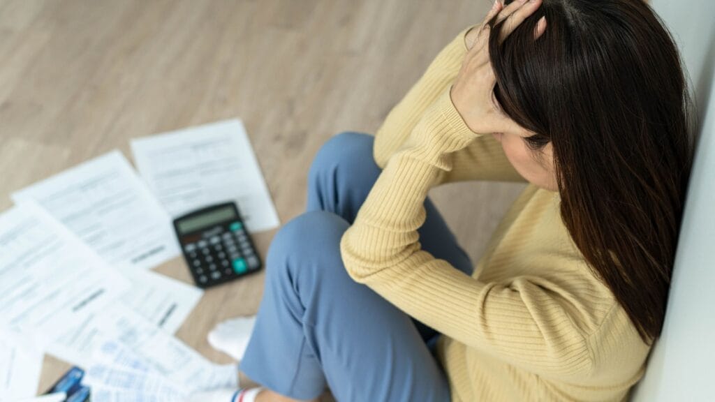 Mulher preocupada analisando extrato bancário e contas acumuladas