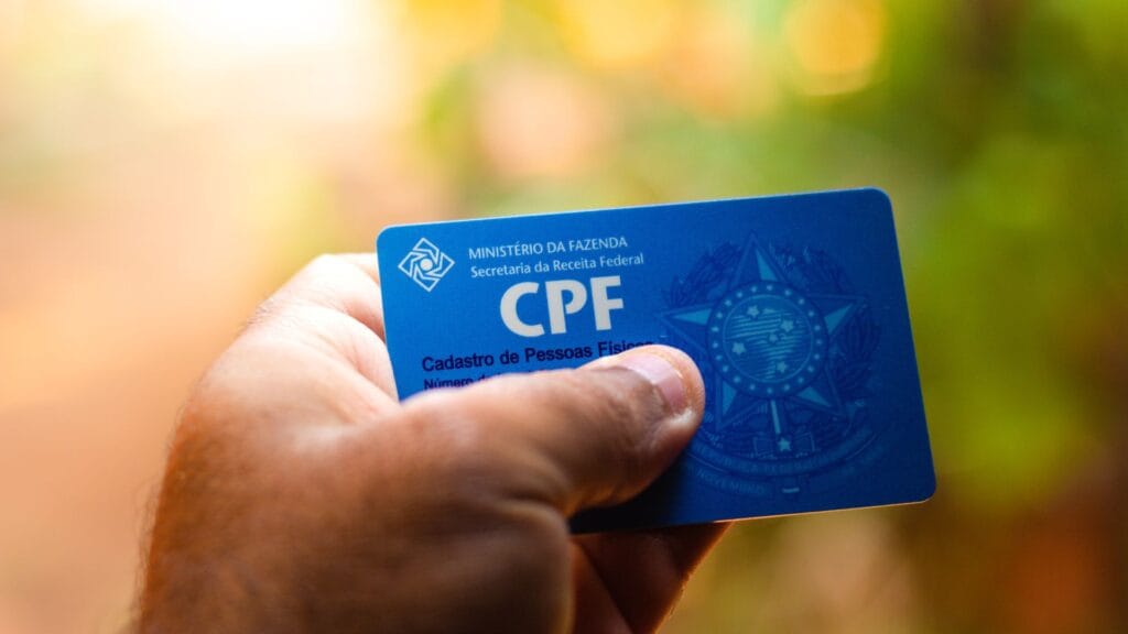 UMA MÃO SEGURANDO UM CPF INDICANDO PORQUE É BOM CONSULTAR